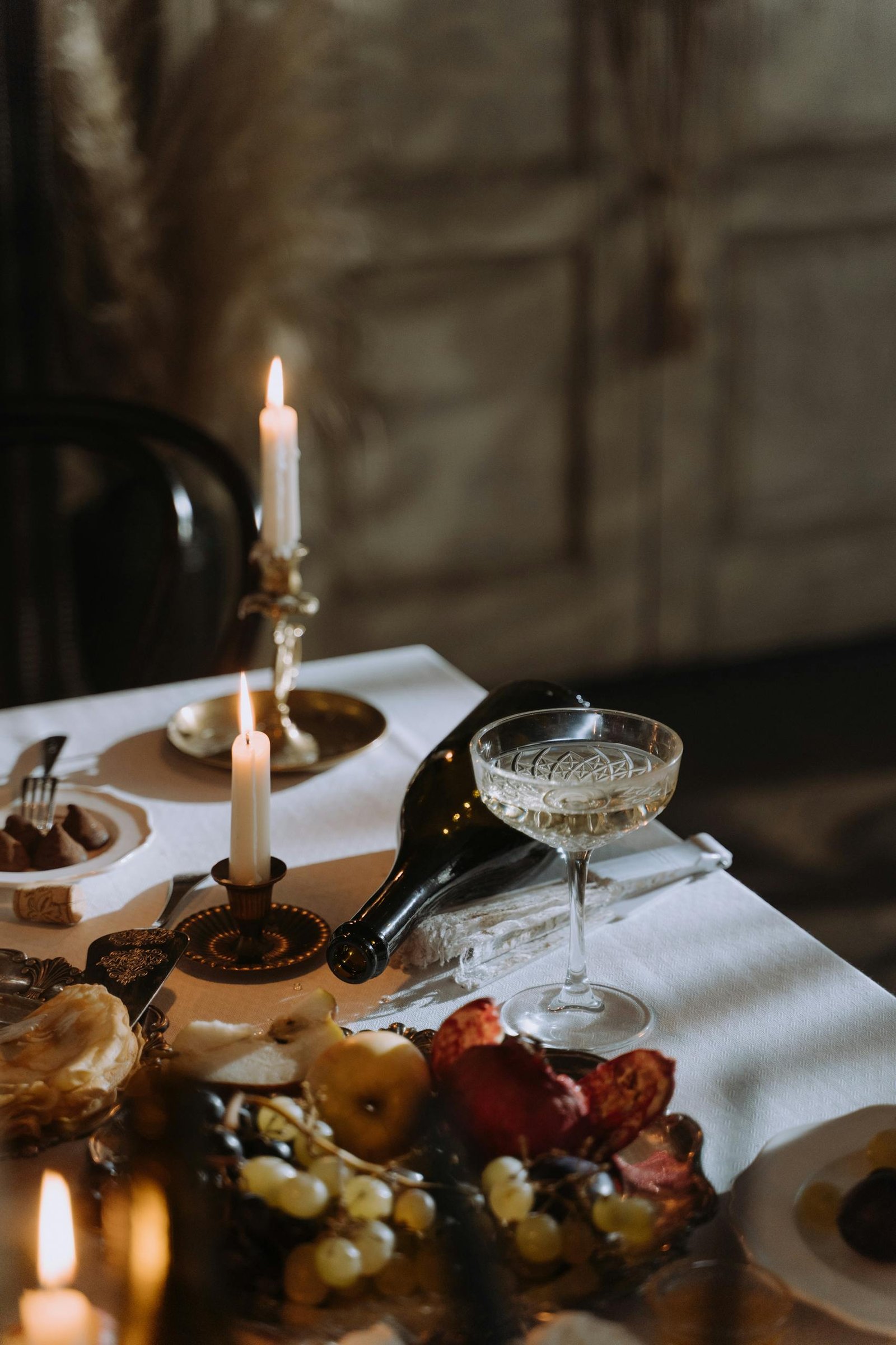A sophisticated dining table with candles, wine, and gourmet food for a cozy evening.