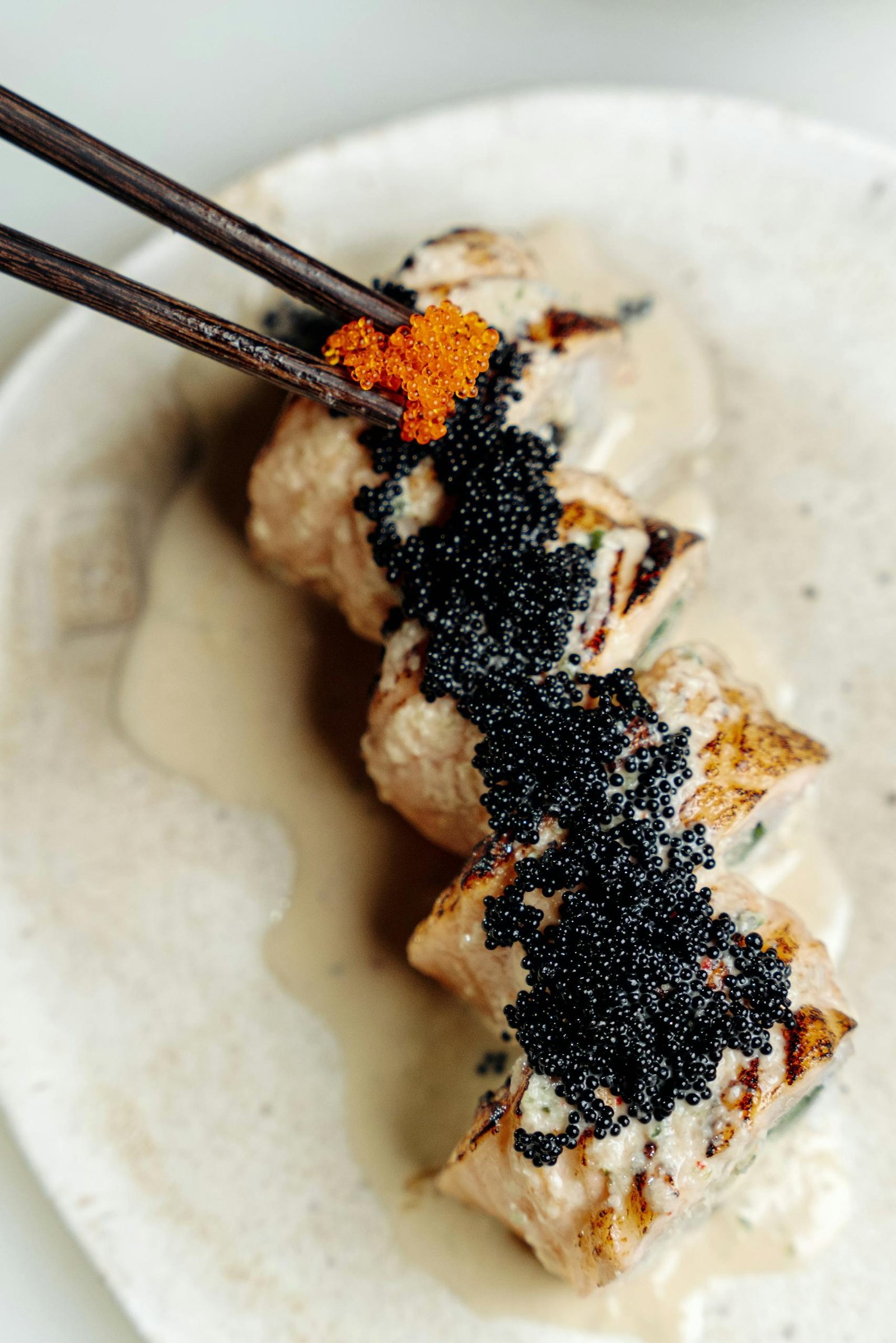 Close-up of gourmet sushi rolls topped with black and orange caviar.