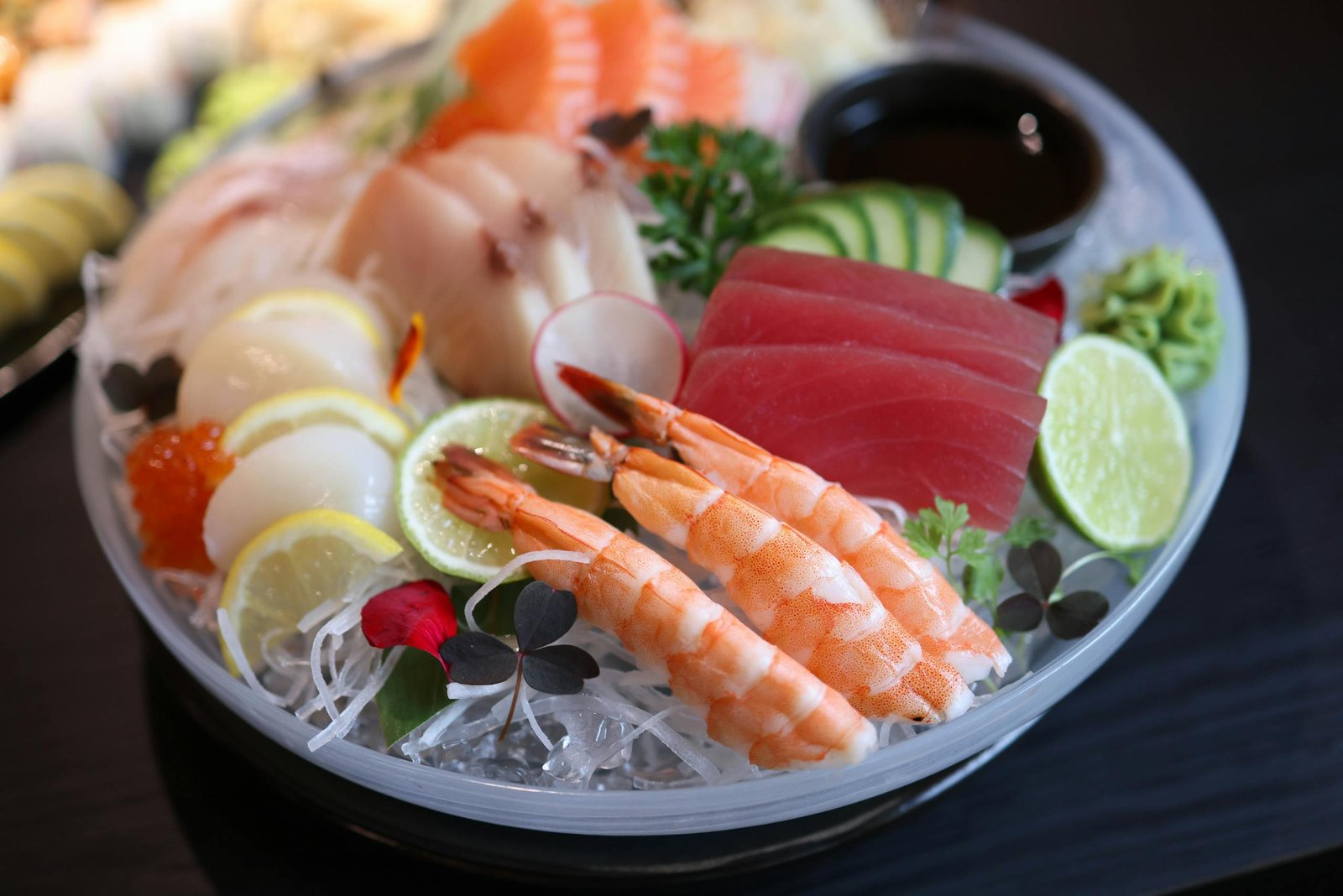 Elegant sushi dish featuring fresh sashimi varieties including tuna, shrimp, and scallops.